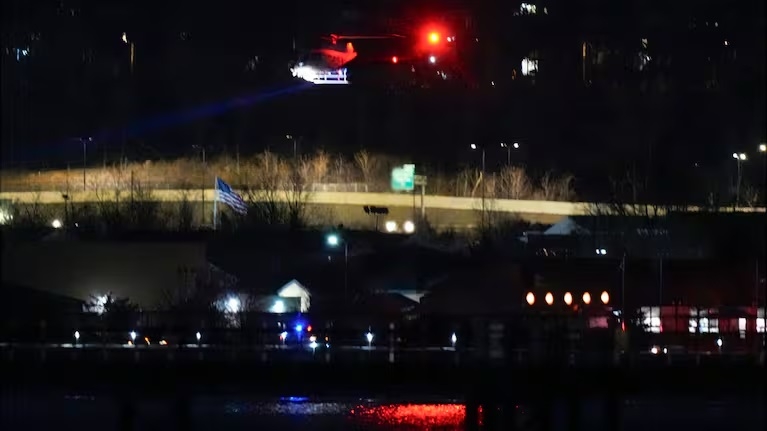 A helicopter uses its searchlight as it flies above the Potomac