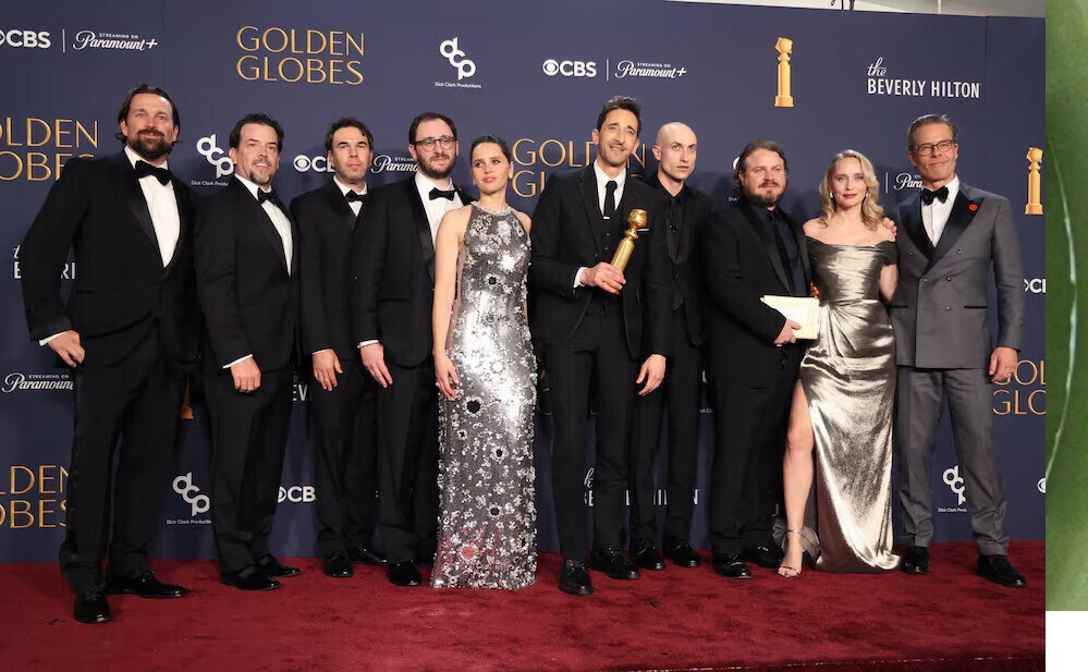The cast of he Brutalist pose with director Brady Corbet after 