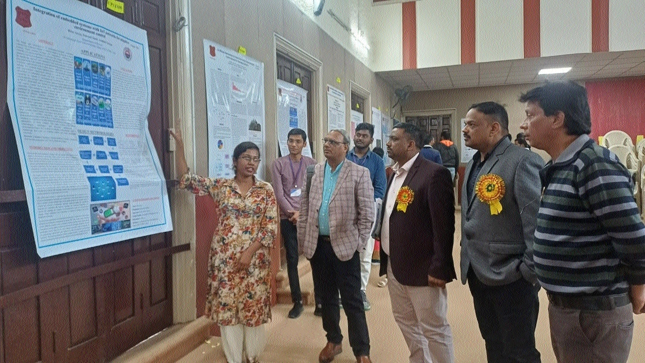A participant explains about her poster to experts and guests at the conference