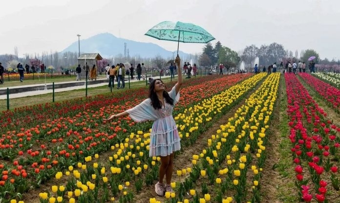 A woman with an umbrella poses among
