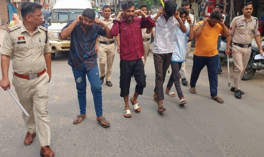Police taking out a public parade of the accused in Katiapara 