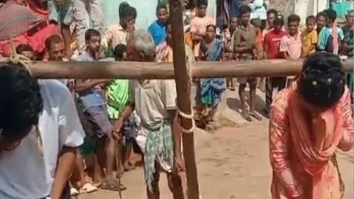 Couple tied to wooden plough