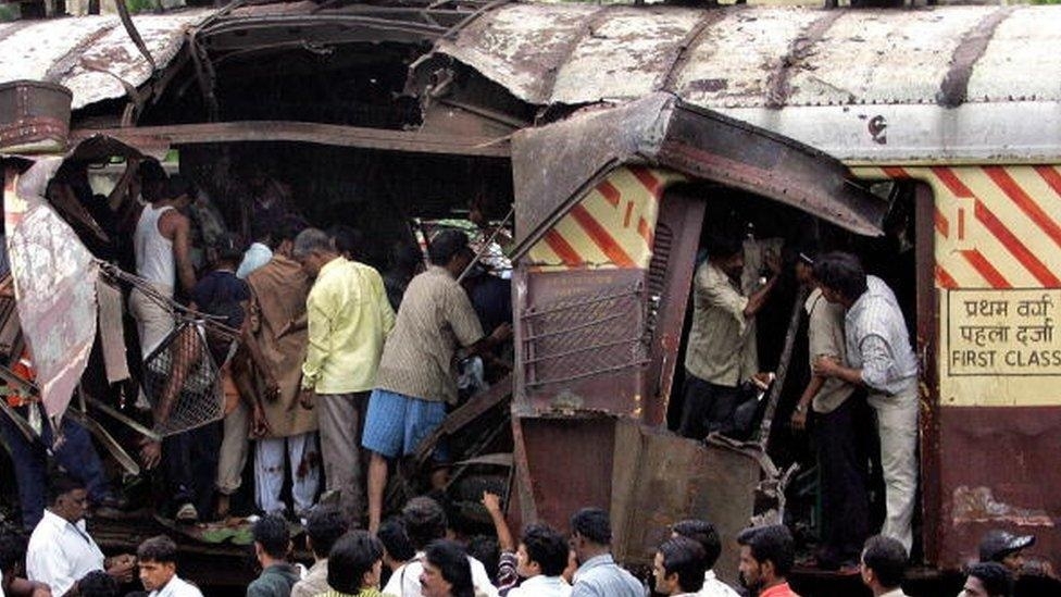 A train coach is damaged by a bomb blast