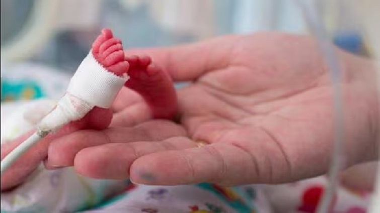 Infant found hanging from wires of device 