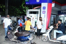 Two-wheeler riders queued at a filling station after being denied for refilling fuel without helmet 