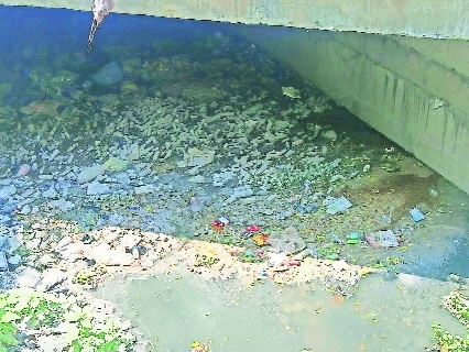 Garbage accumulated under the bridge that runs over the dried up Naag river 