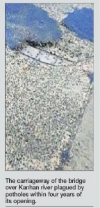 Potholes expose iron bars on four years old bridge on Kanhan river
