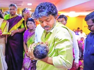 Tamil Nadu Chief Minister C Joseph Vijay holds a newborn baby